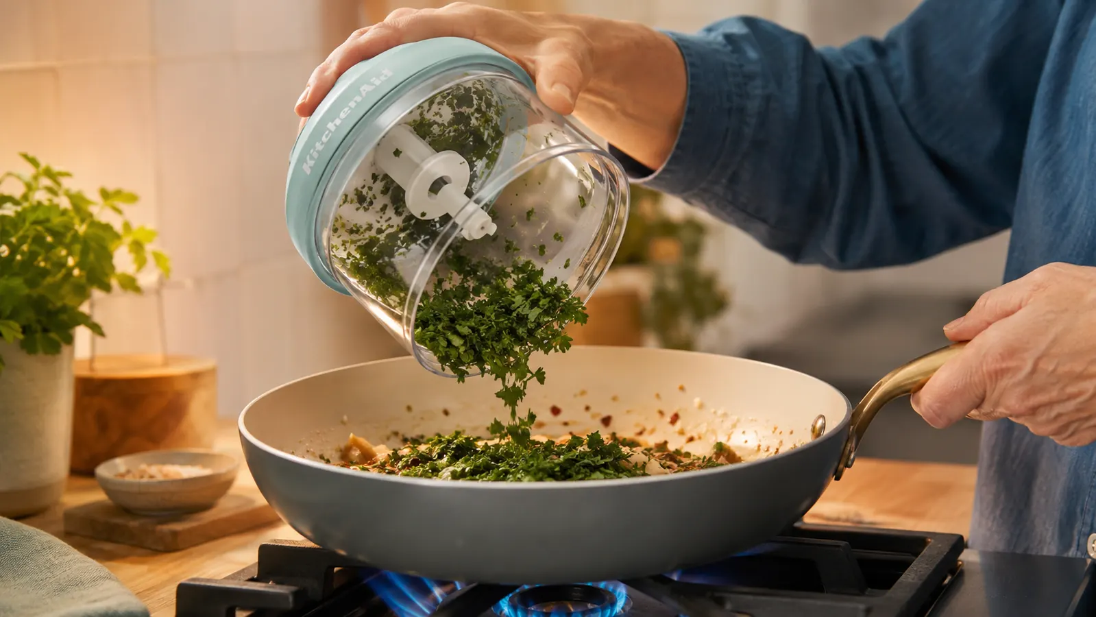 The aqua KitchenAid 3.5 Cup Food Chopper disassembled with bowl, blade, and lid laid flat on a kitchen towel ready to be washed
